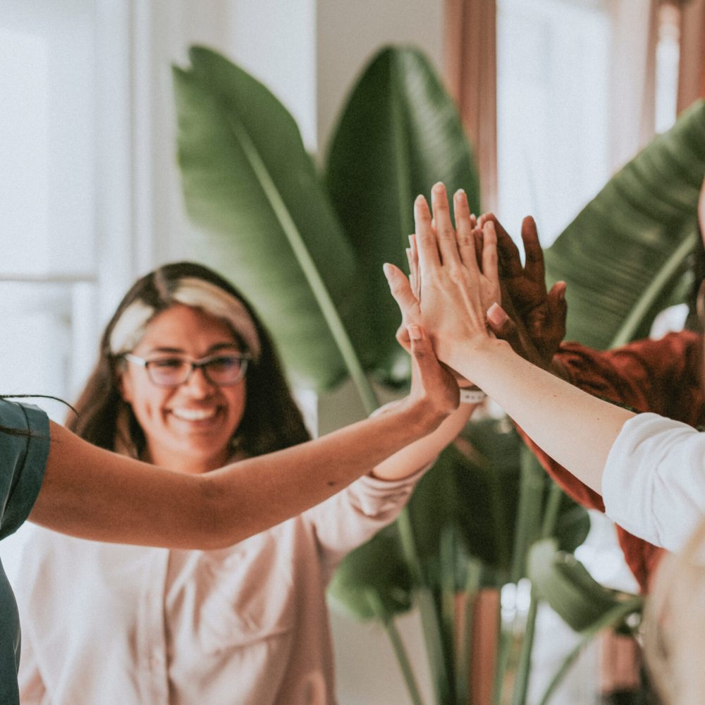 Businesswomen putting hands in the middle